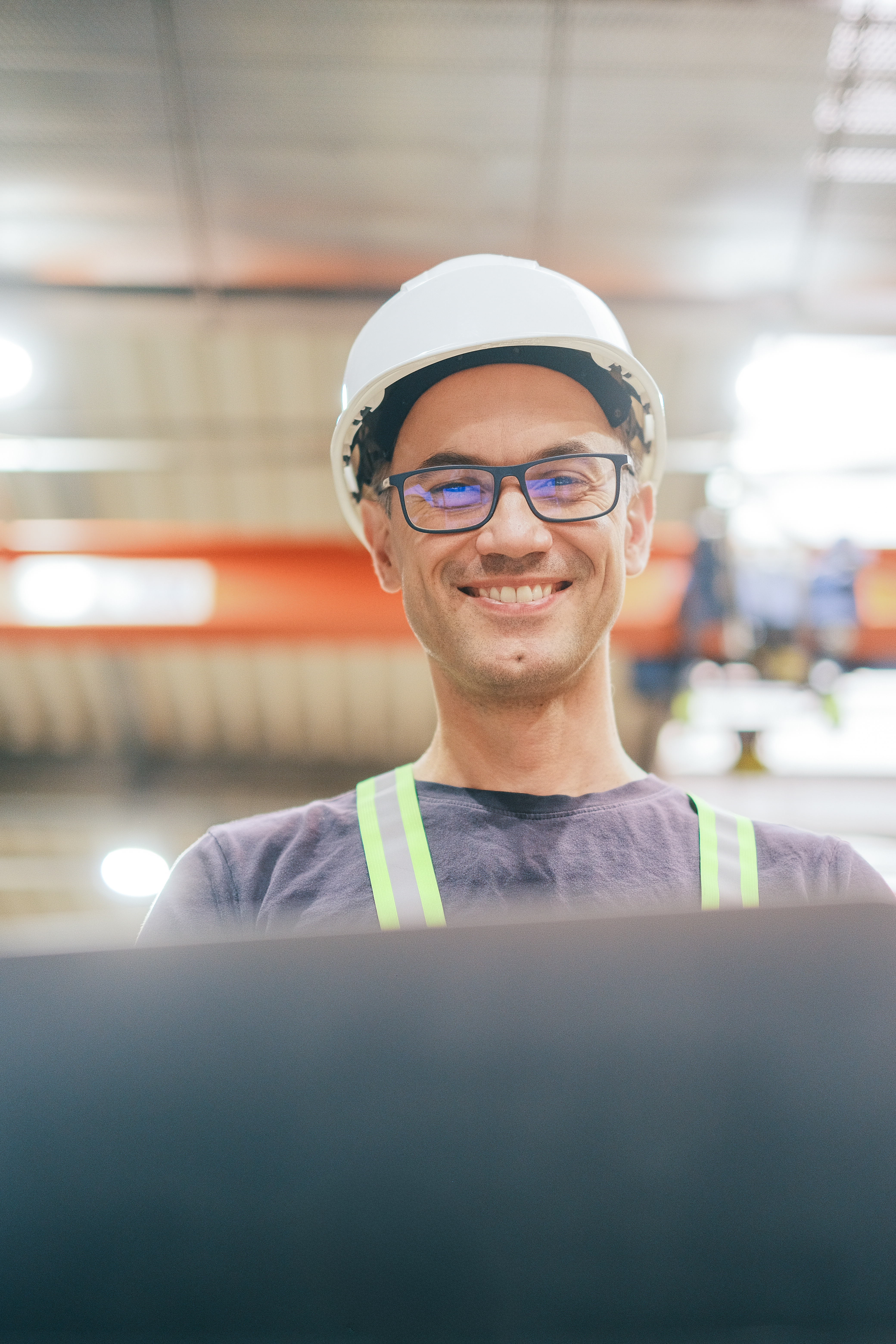 Uśmiechnięty inżynier automatyki Green Climate podczas pracy w zakładzie przemysłowym we Wrocławiu